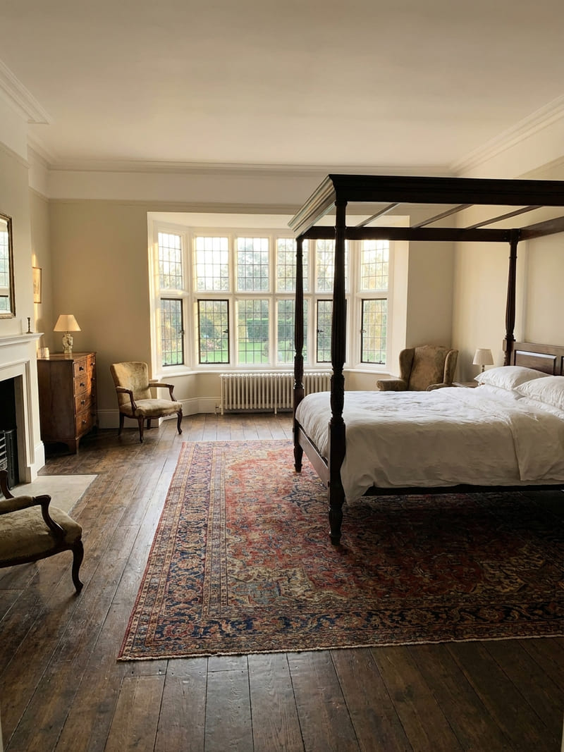 Suite principale, baie vitrée à plomb, lit à colonnes, plancher en bois d’origine